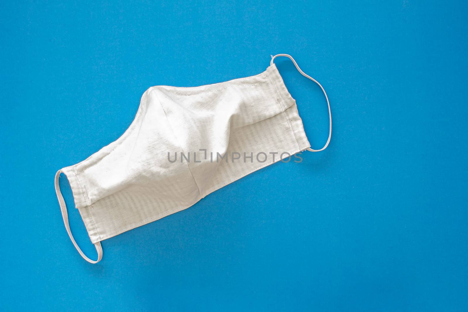 White homemade face mask for adults on a blue background by oasisamuel