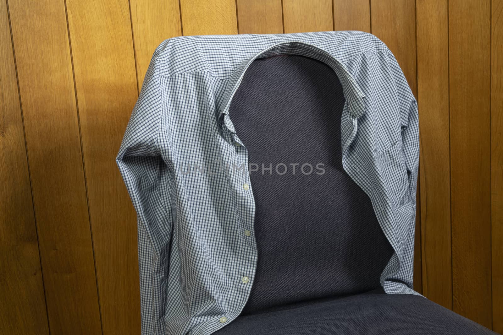 a men's shirt resting on a chair