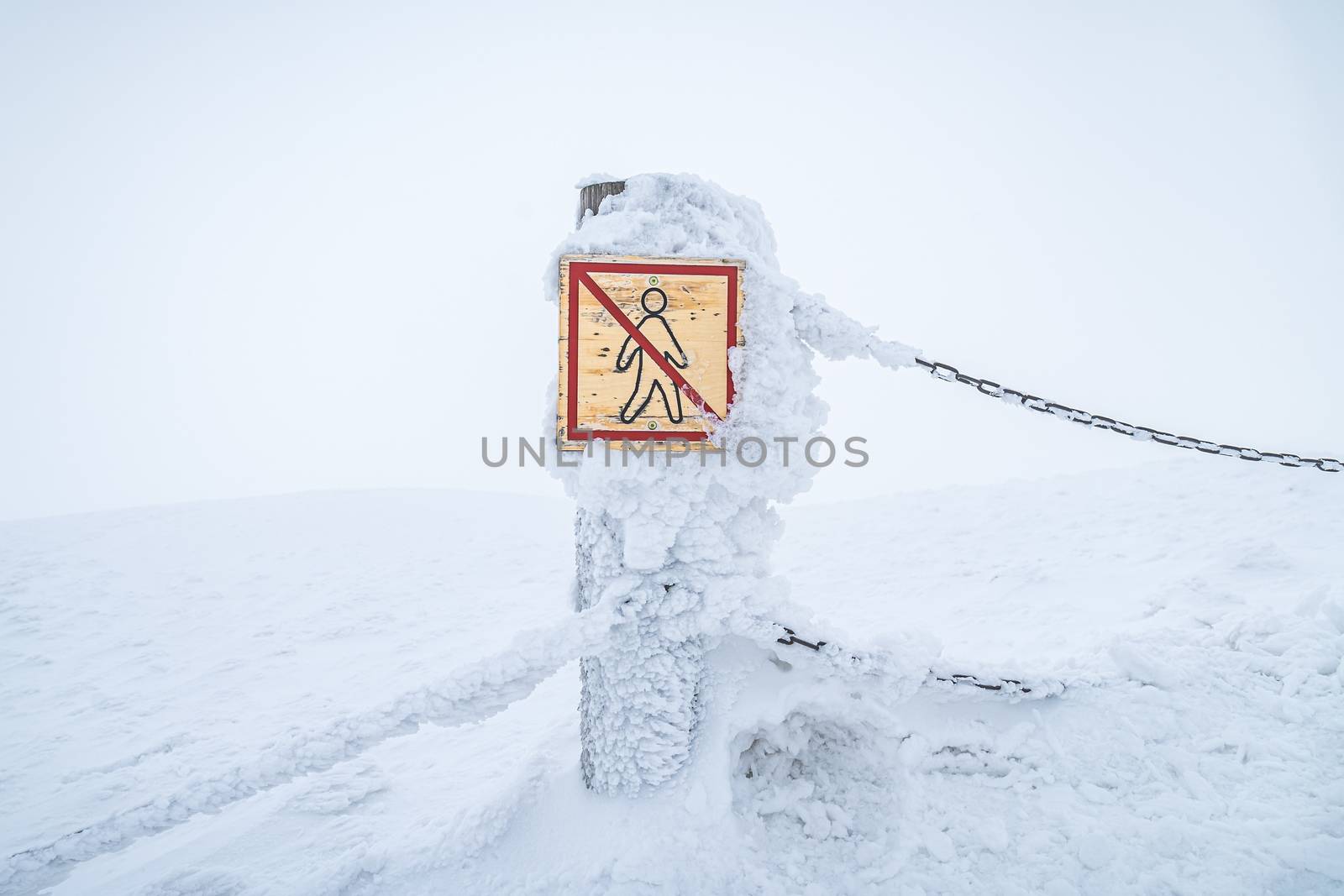 No trespassing sign warning tourists to keep them safe in Krkonose national park. Warning sign covered with snow. by petrsvoboda91