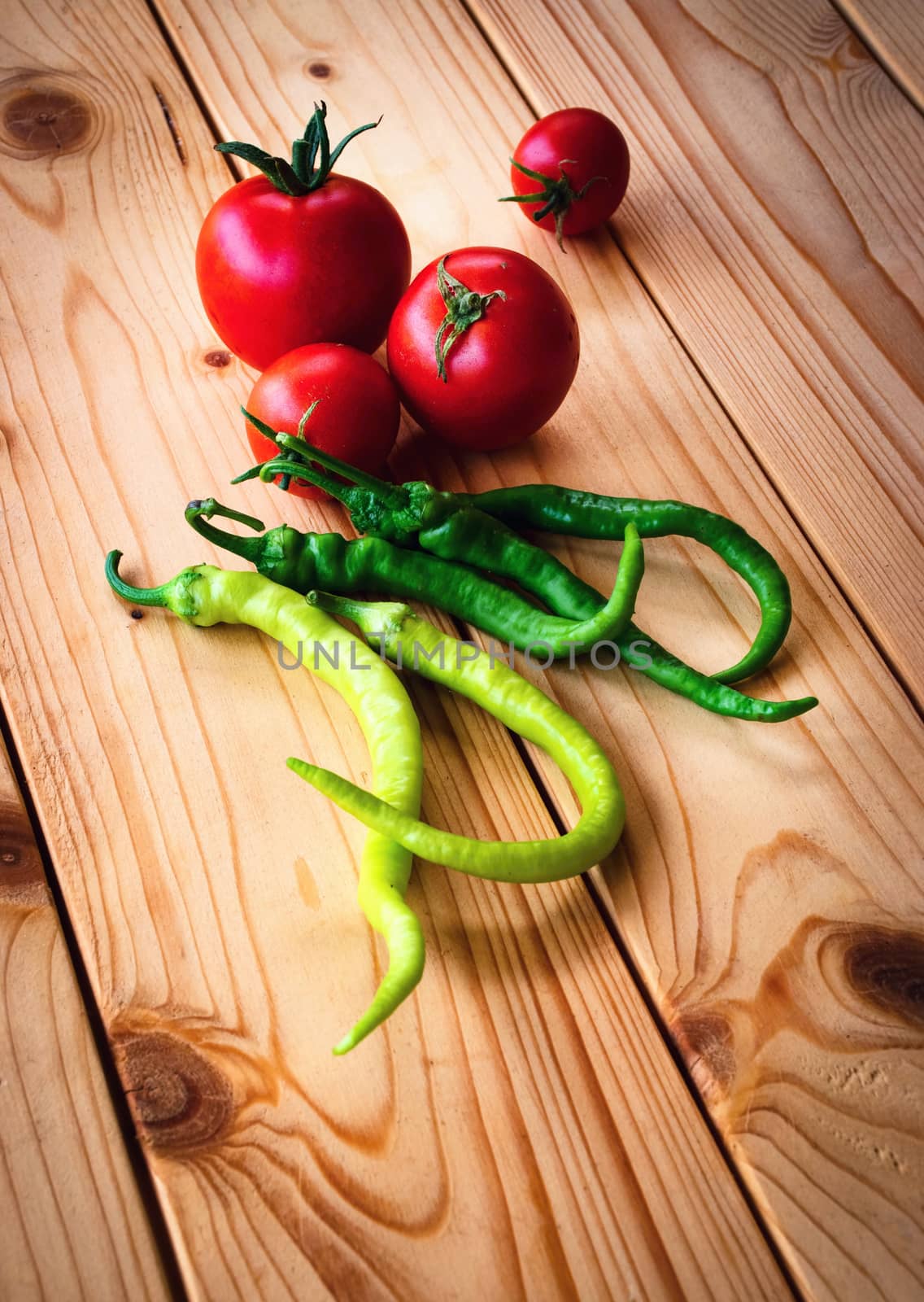 tomatoes and peppers on wooden table by Ahojdoma