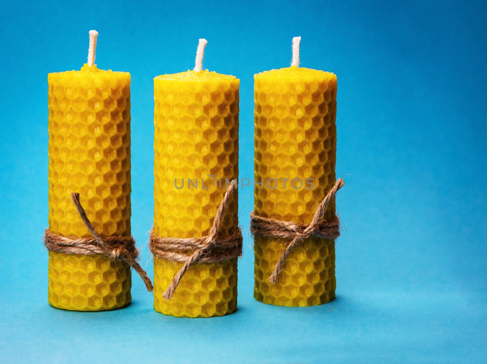 background three candles of yellow beeswax