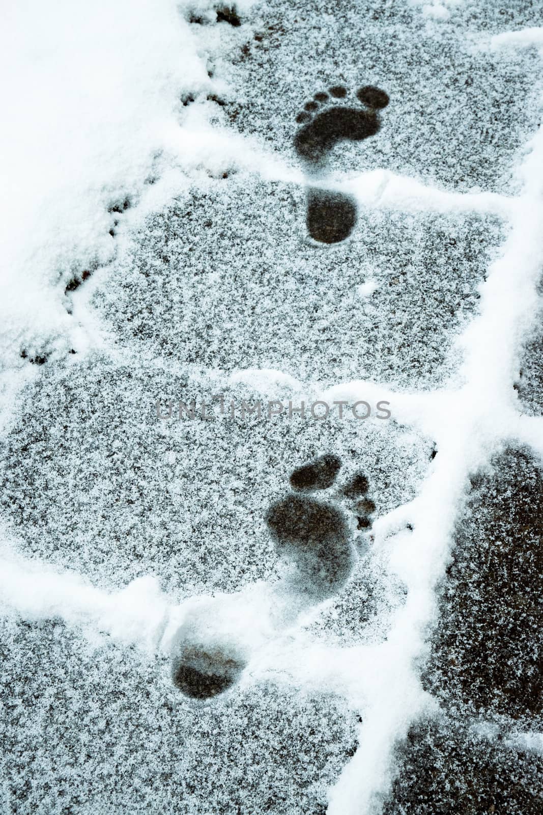 seasonal background two imprints of bare feet in the snow