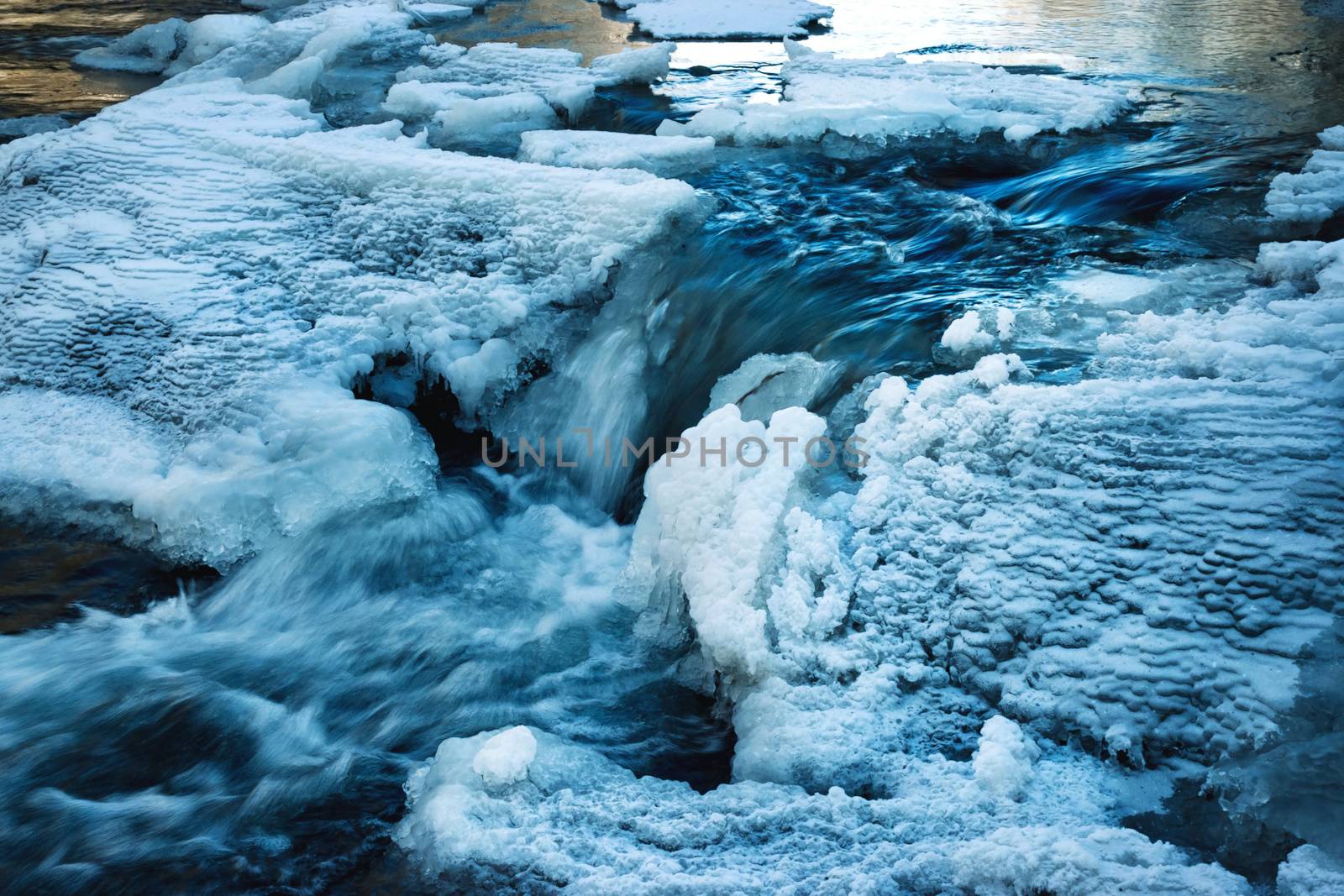 nature seasonal background frozen river with cascades in winter
