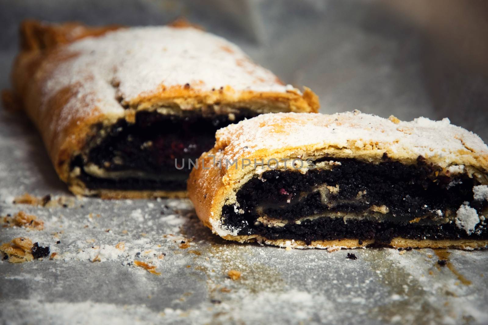 food background roll filled with poppy seeds on baking paper