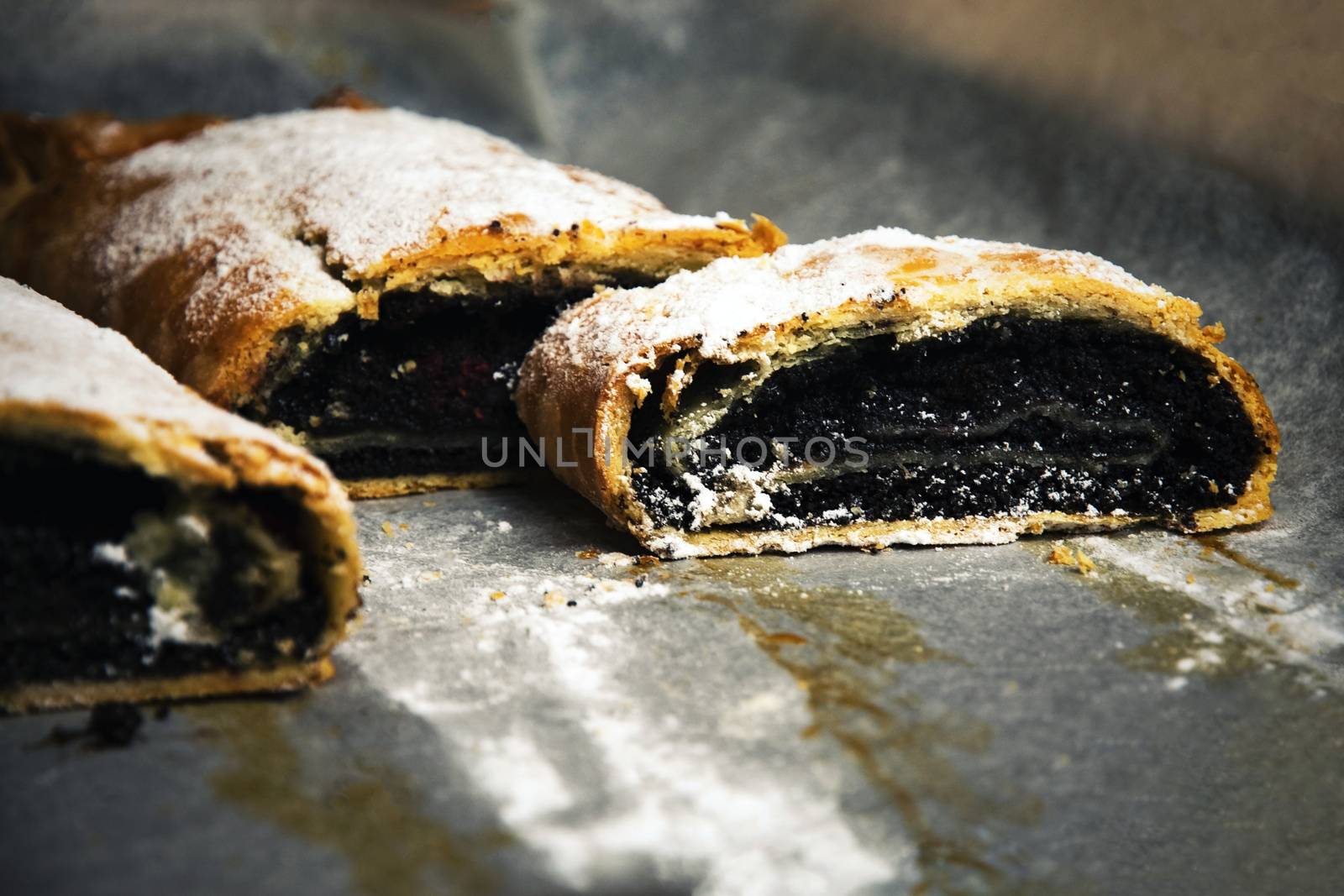 food background roll filled with poppy seeds on baking paper