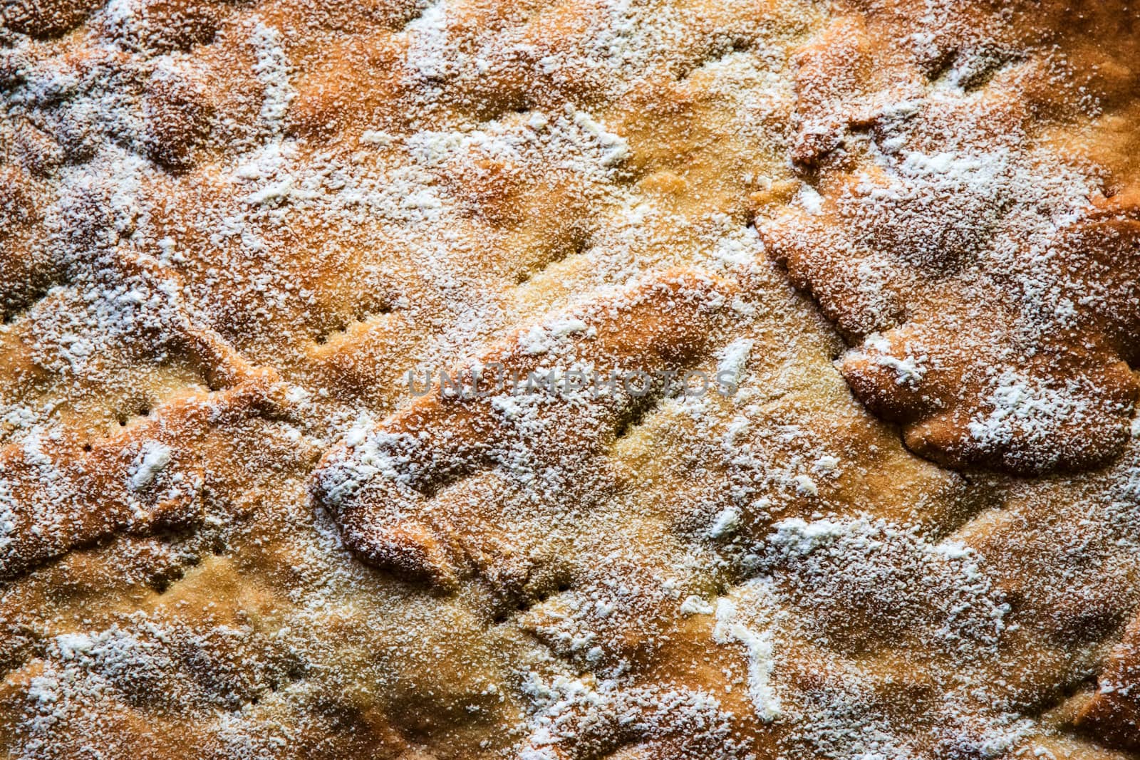 background or texture an uneven surface of cake sprinkled with sugar