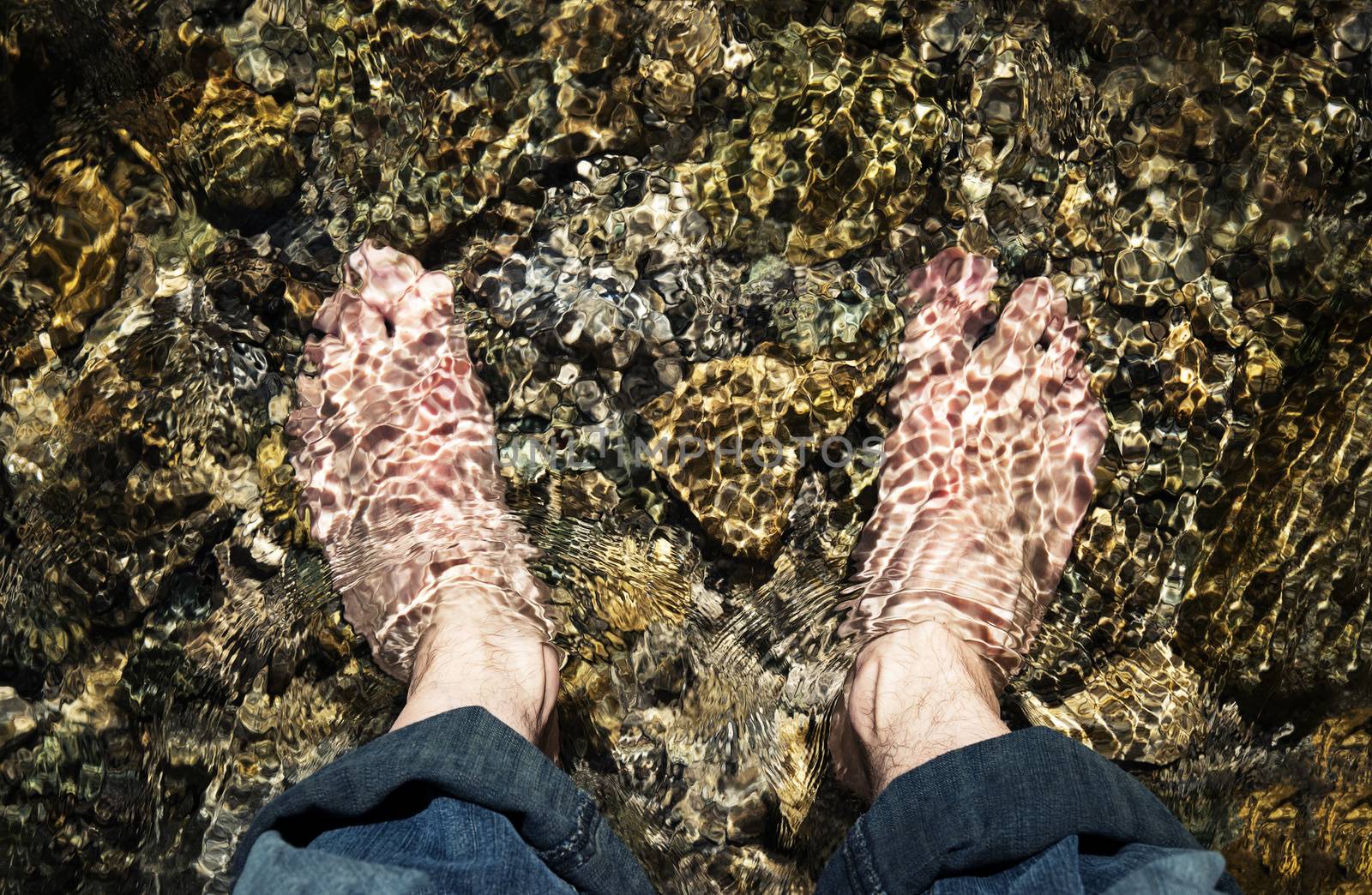 bare feet in a cold mountain stream by Ahojdoma