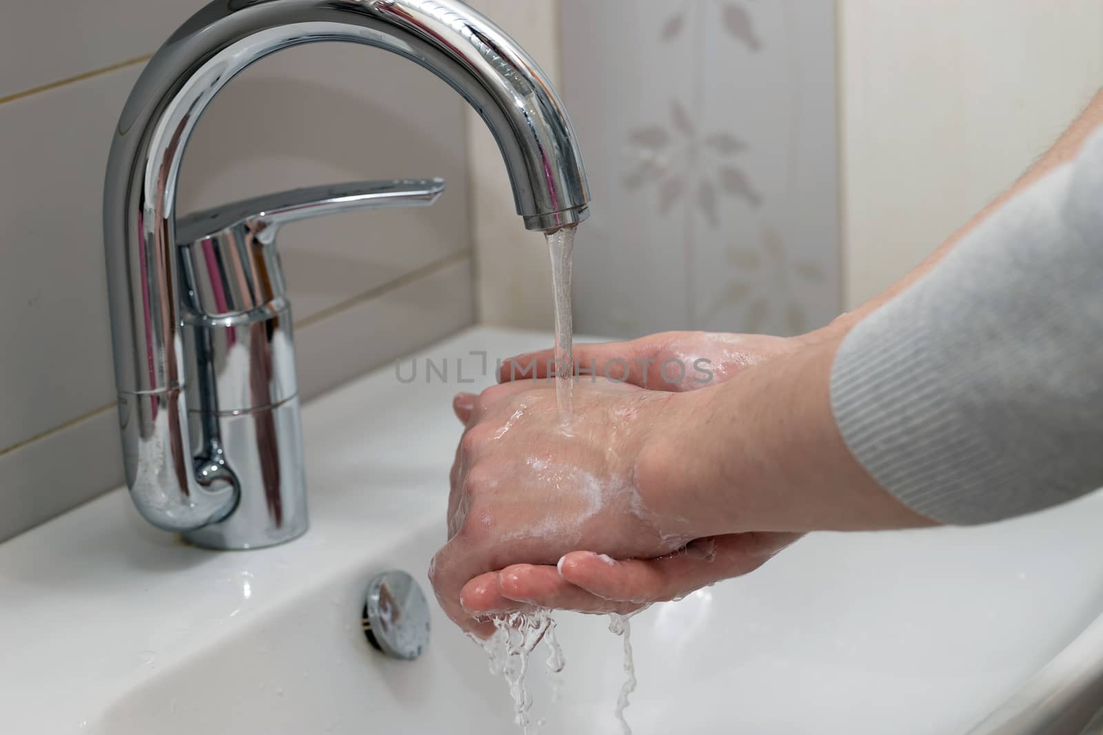 Man washing hands with soap and lathering suds. Protect against the coronavirus. Coronavirus pandemic protection by washing hands frequently. Hygiene to stop spreading coronavirus.