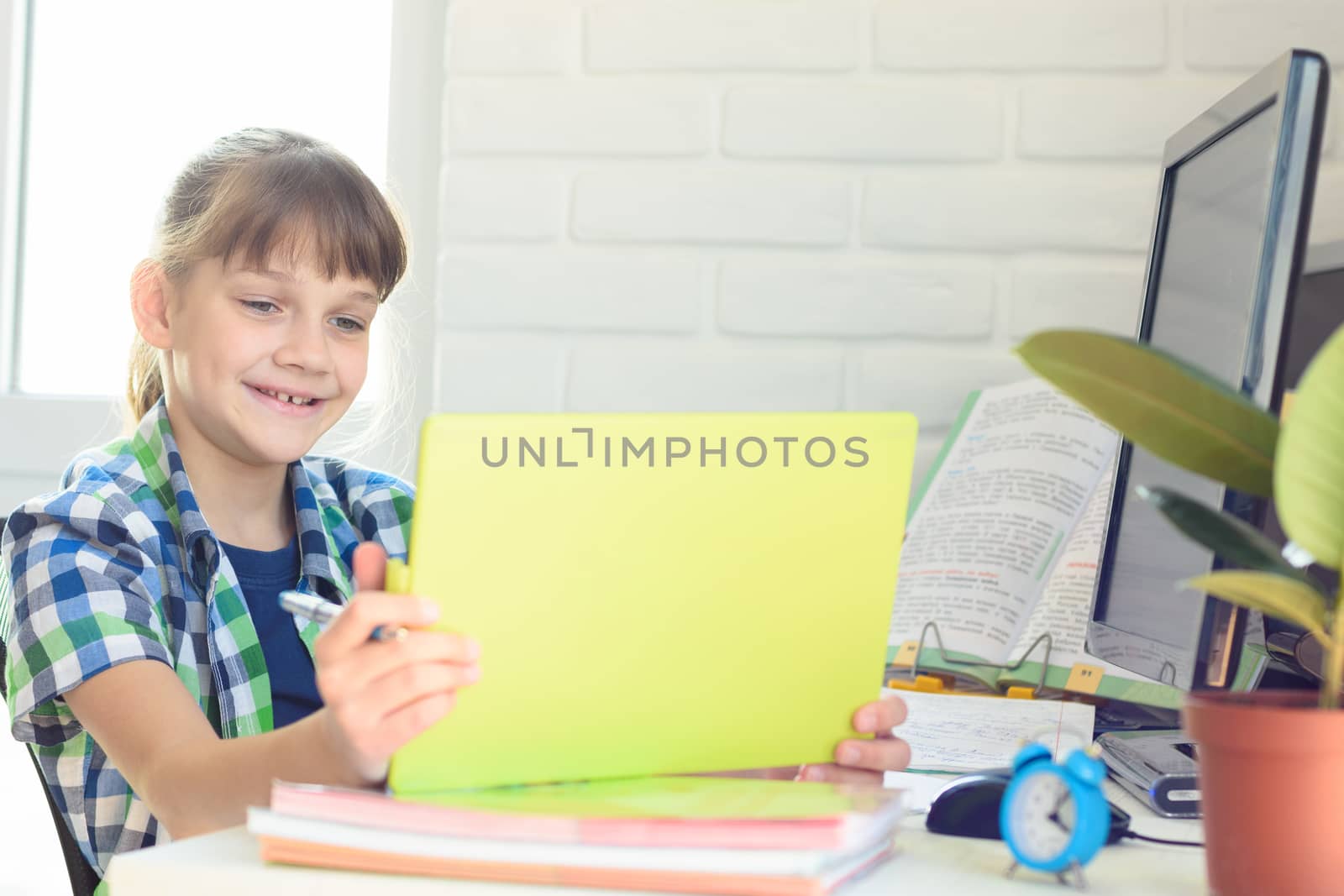 A ten year old girl happily looks at the screen of a tablet computer