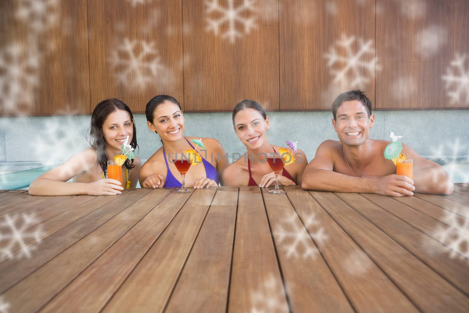 Cheerful people with drinks in swimming pool against snowflakes