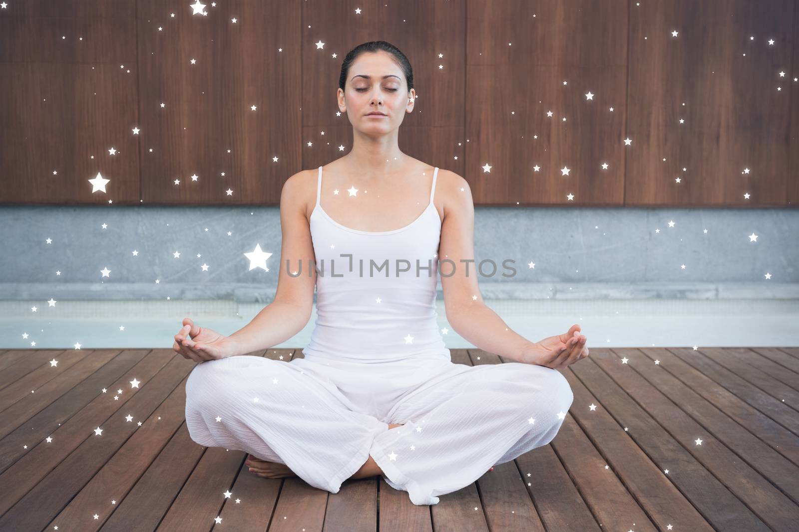 Peaceful woman in white sitting in lotus pose by Wavebreakmedia