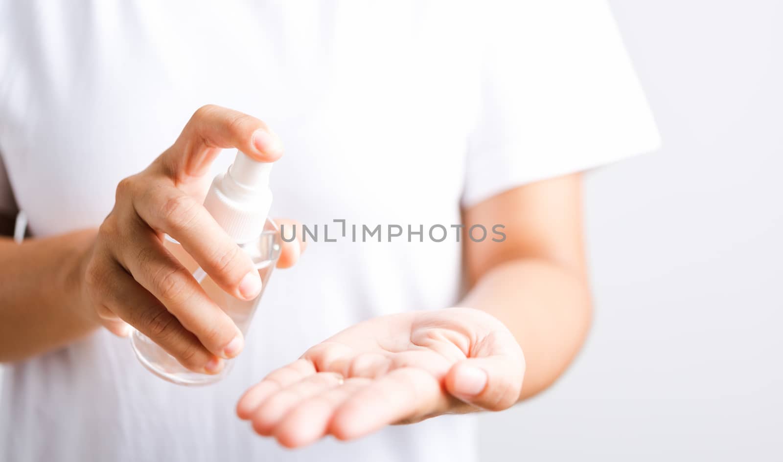 Closeup Hand Asian young woman applying spray pump dispenser sanitizer alcohol on hand wash cleaning, hygiene prevention COVID-19 or coronavirus protection concept, isolated on white background