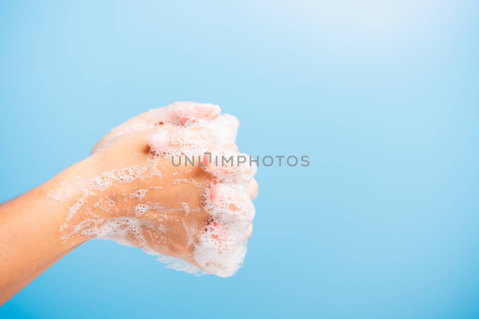 Closeup body care Asian young woman washing hands with soap have foam, hygiene prevention COVID-19 or coronavirus protection concept, isolated on blue background