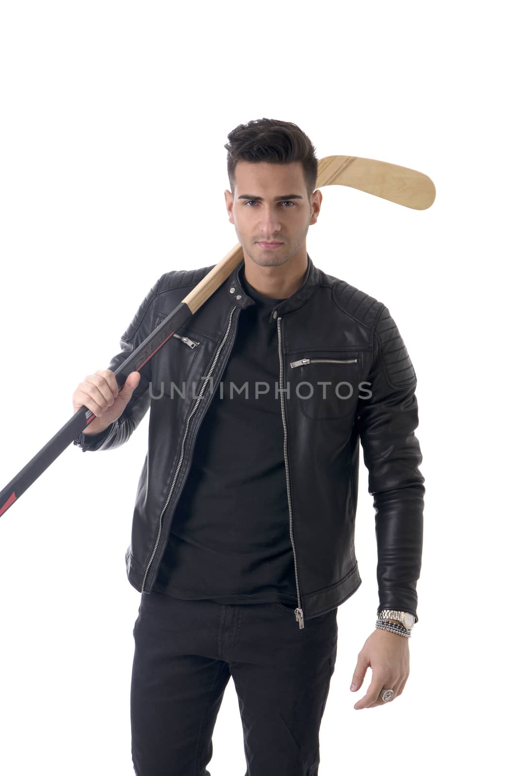 Portrait of a handsome man in blue hoodie posing for camera with hockey stick in his hands