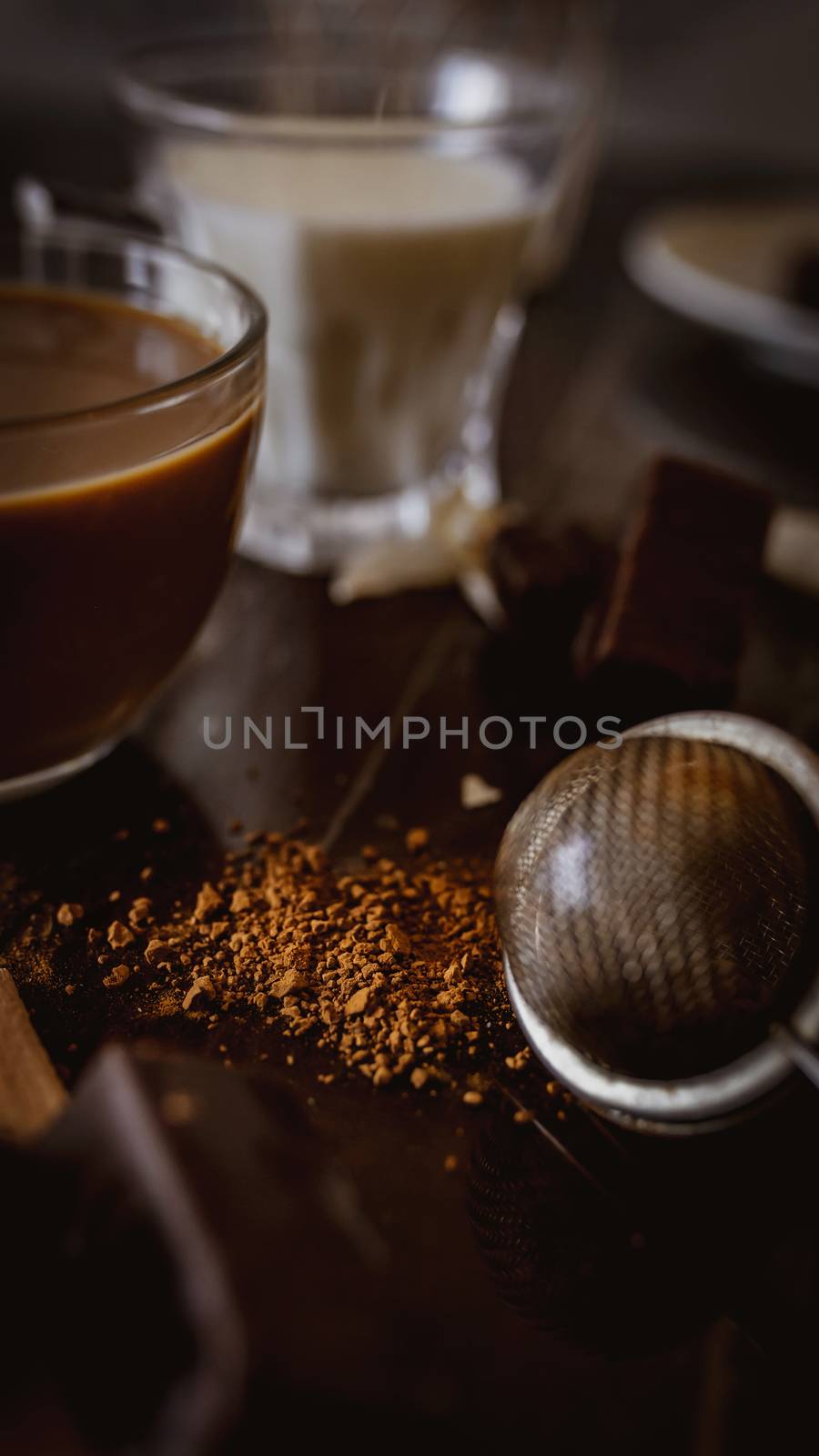 Cup of hot cappuccino with cocoa powder with chocolate brown background