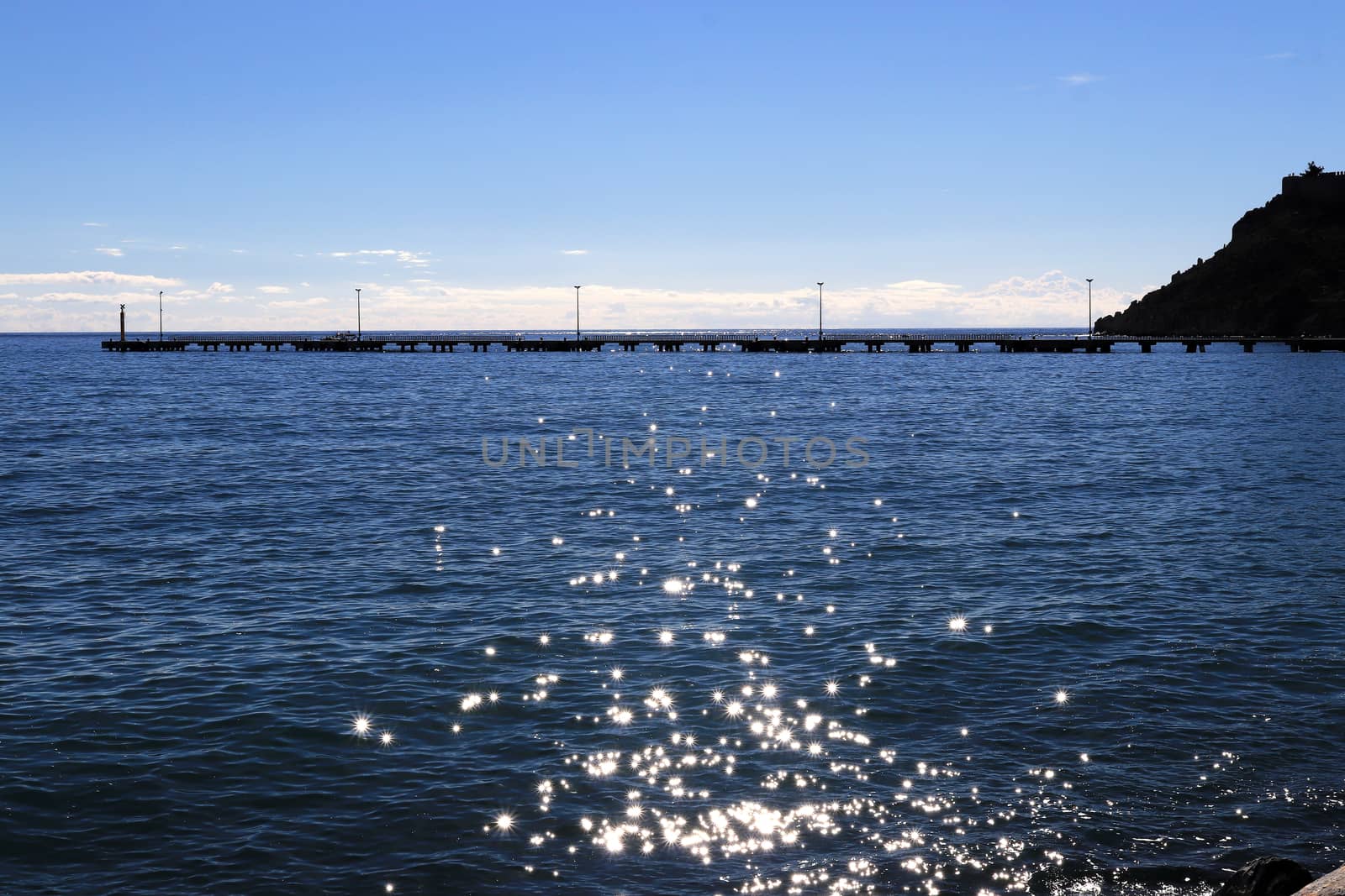 Long pier in the sea with sunshine reflection landscape.
