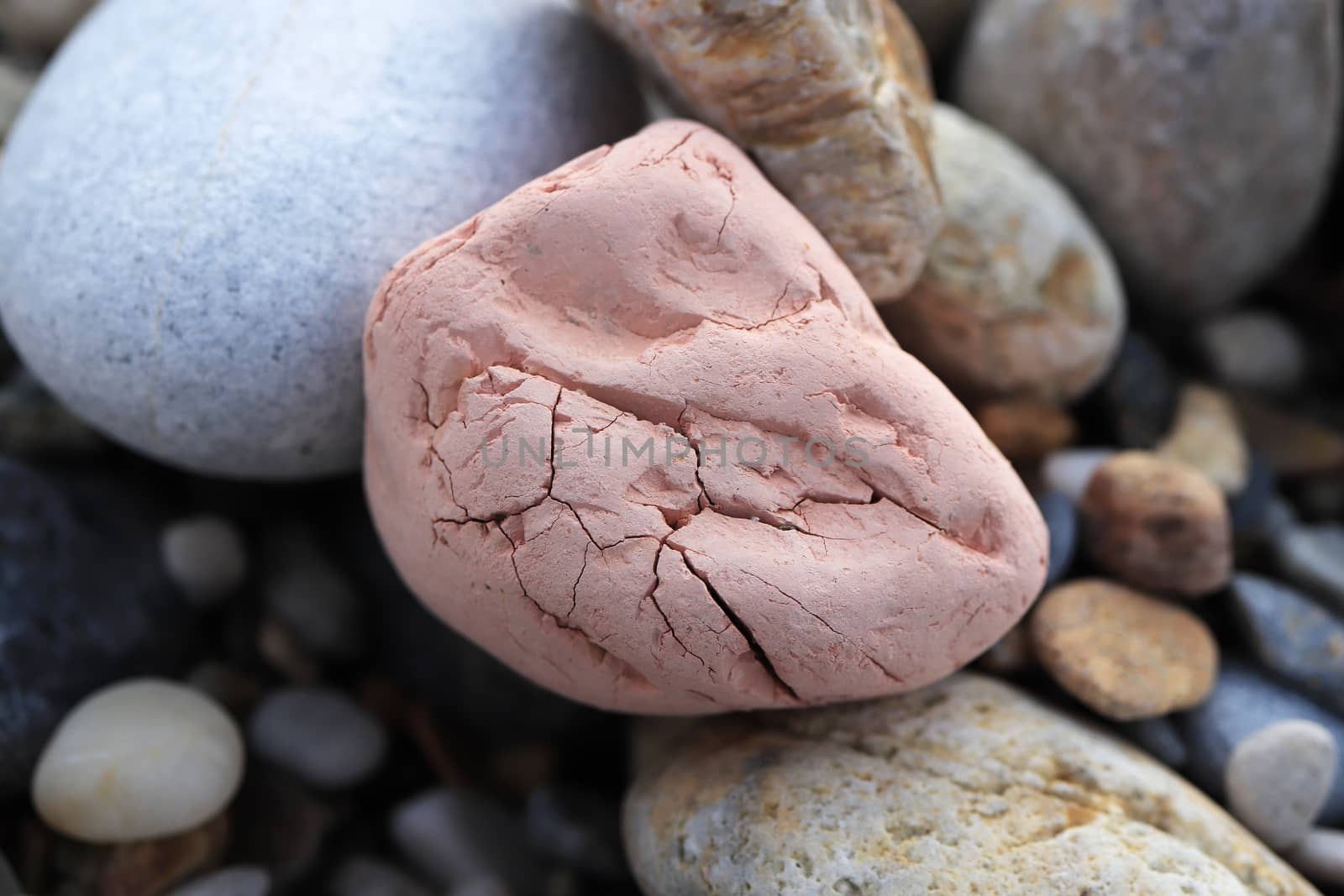 Pink stone with cobblestones on the beach.