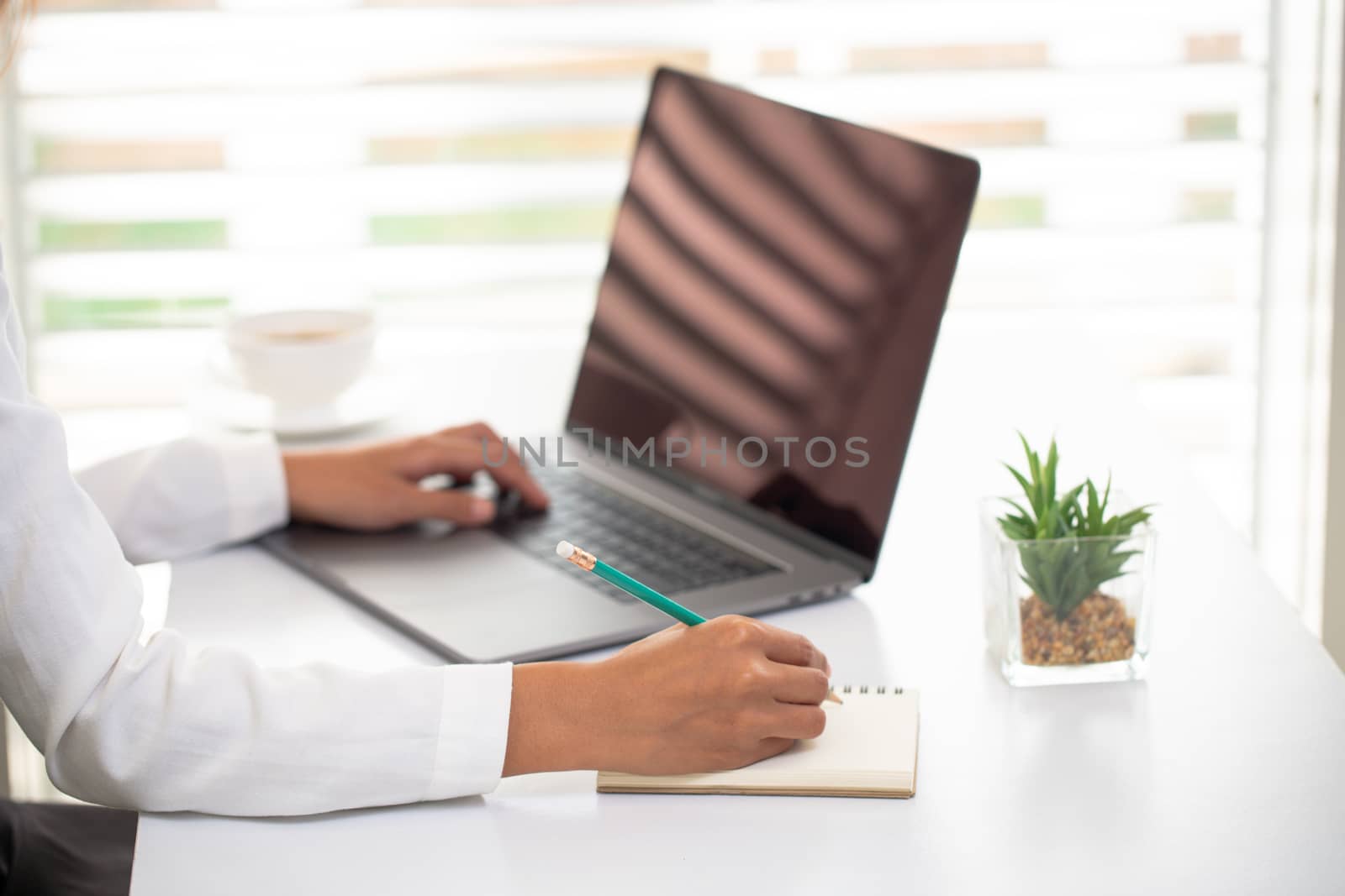 Business people work Laptop screen The hand is taking notes Office room. Online marketing concepts, adult education, e-learning Office work process Online training. Marketing accounting.