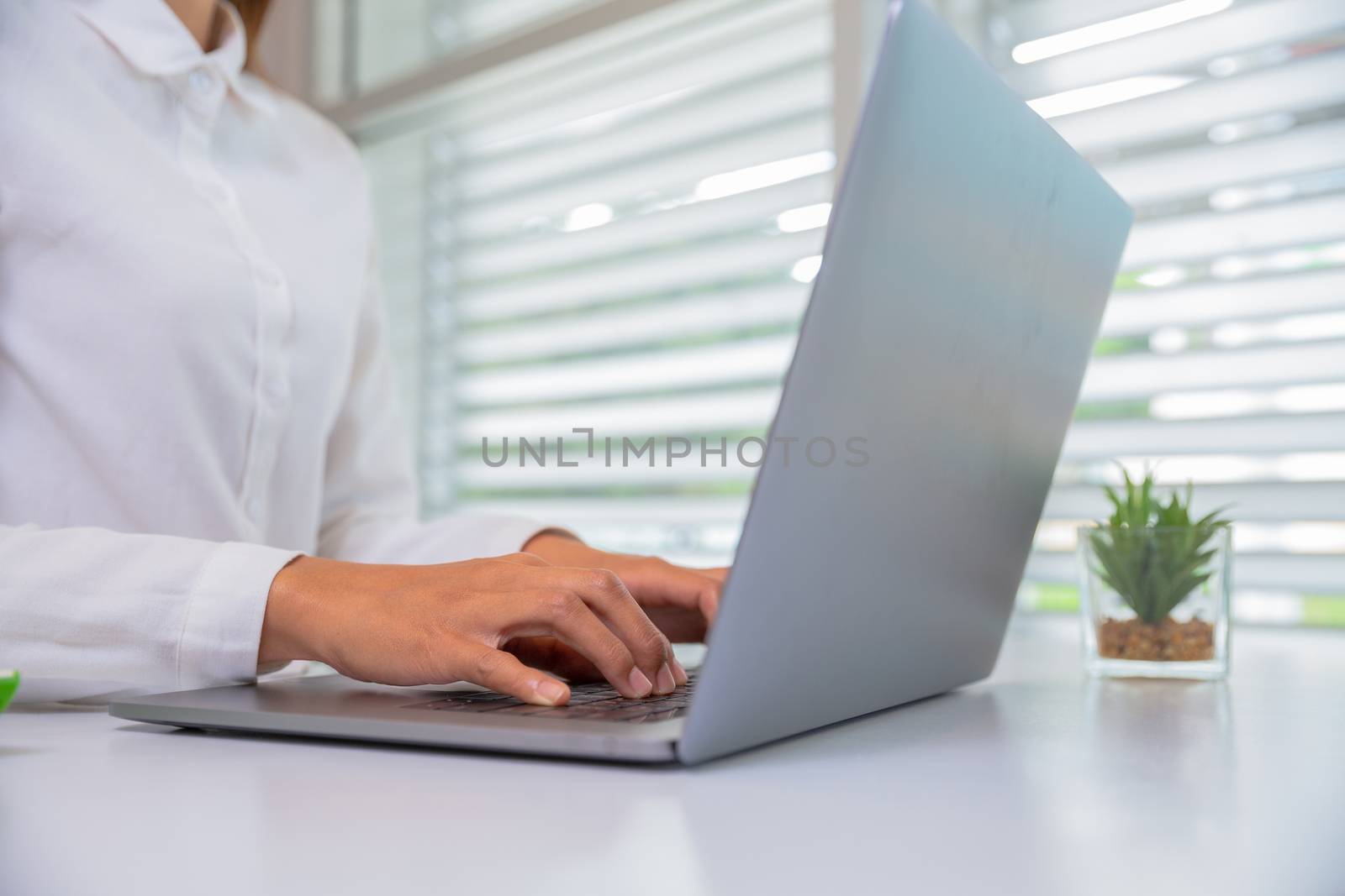 Businesswoman or accountant. Work in a creative and modern room.The laptop is on the table. A business person resting his hand on a laptop Working concept Business planning.