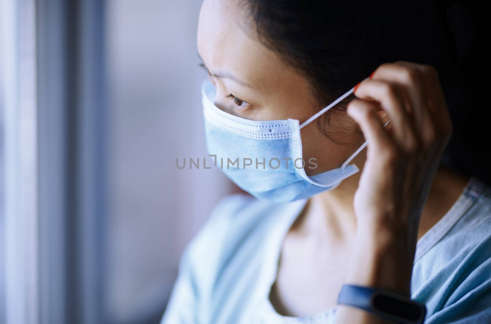 Woman staying at home wearing protective surgical mask by Novic