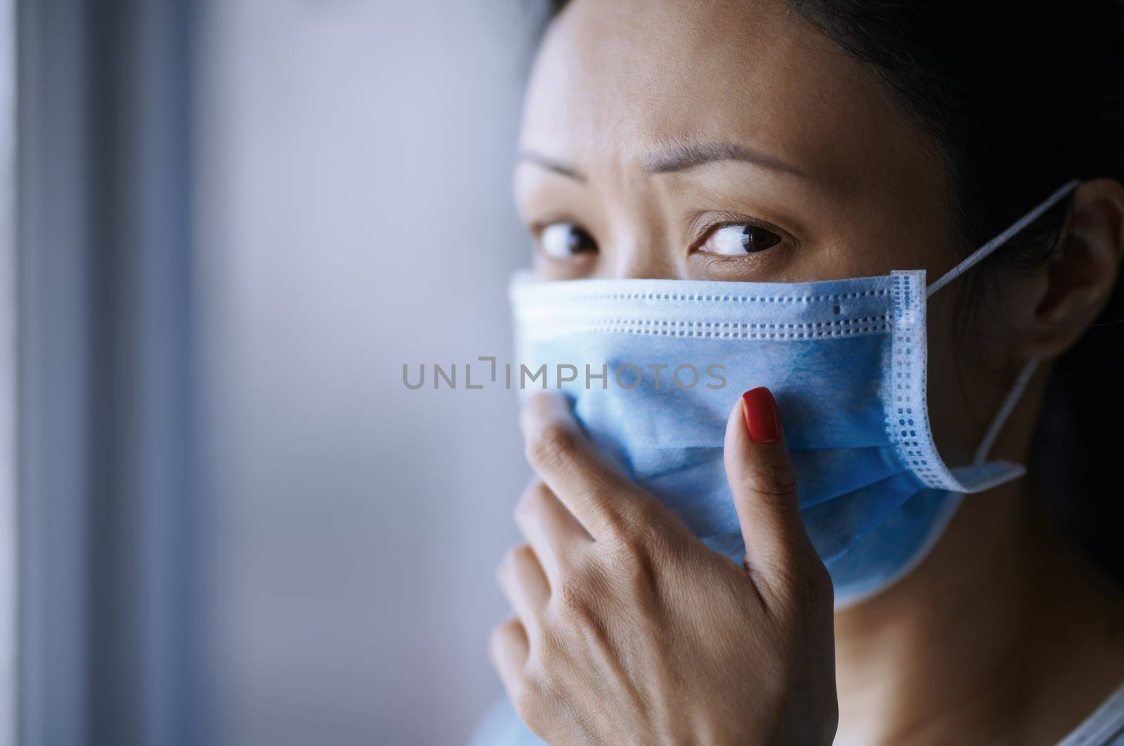 Woman staying at home wearing protective surgical mask