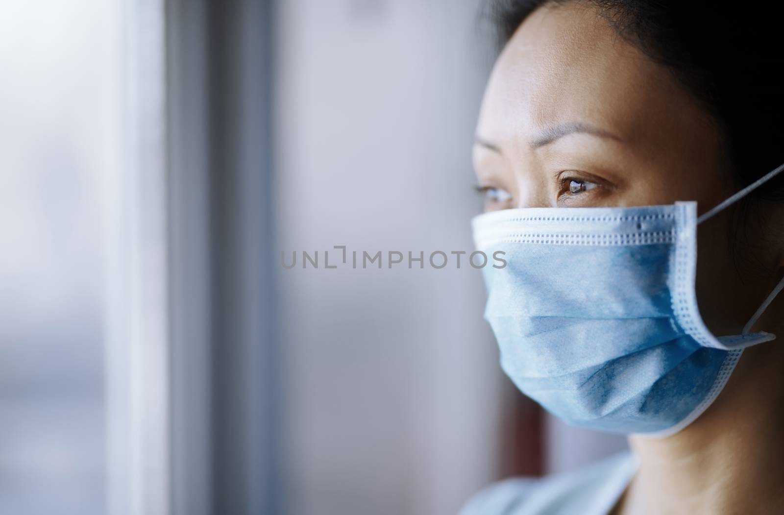 Woman staying at home wearing protective surgical mask