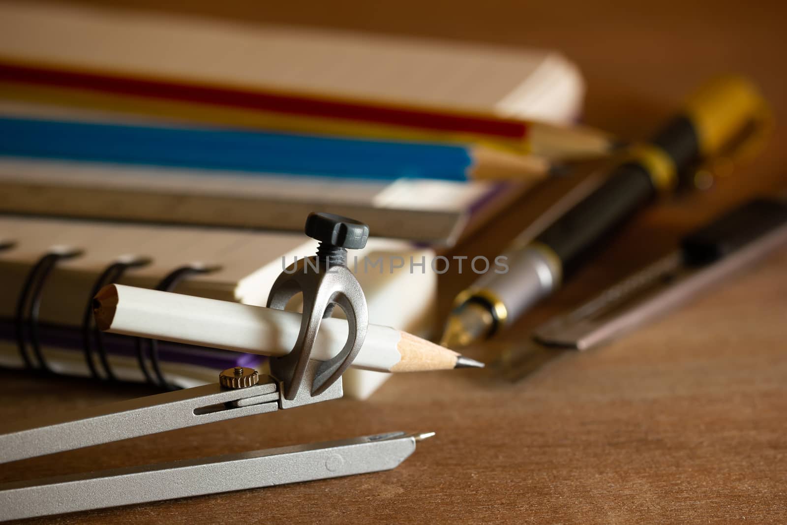 Compass for drawing and stationary on wooden table. by SaitanSainam