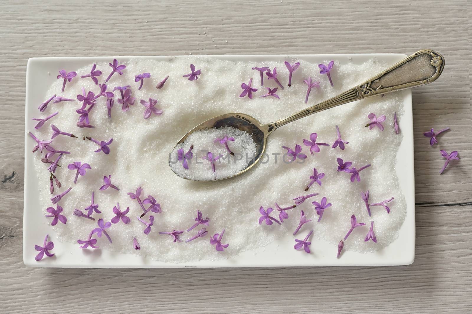 Lilac Sugar In Spoon And Plate On WoodenTable