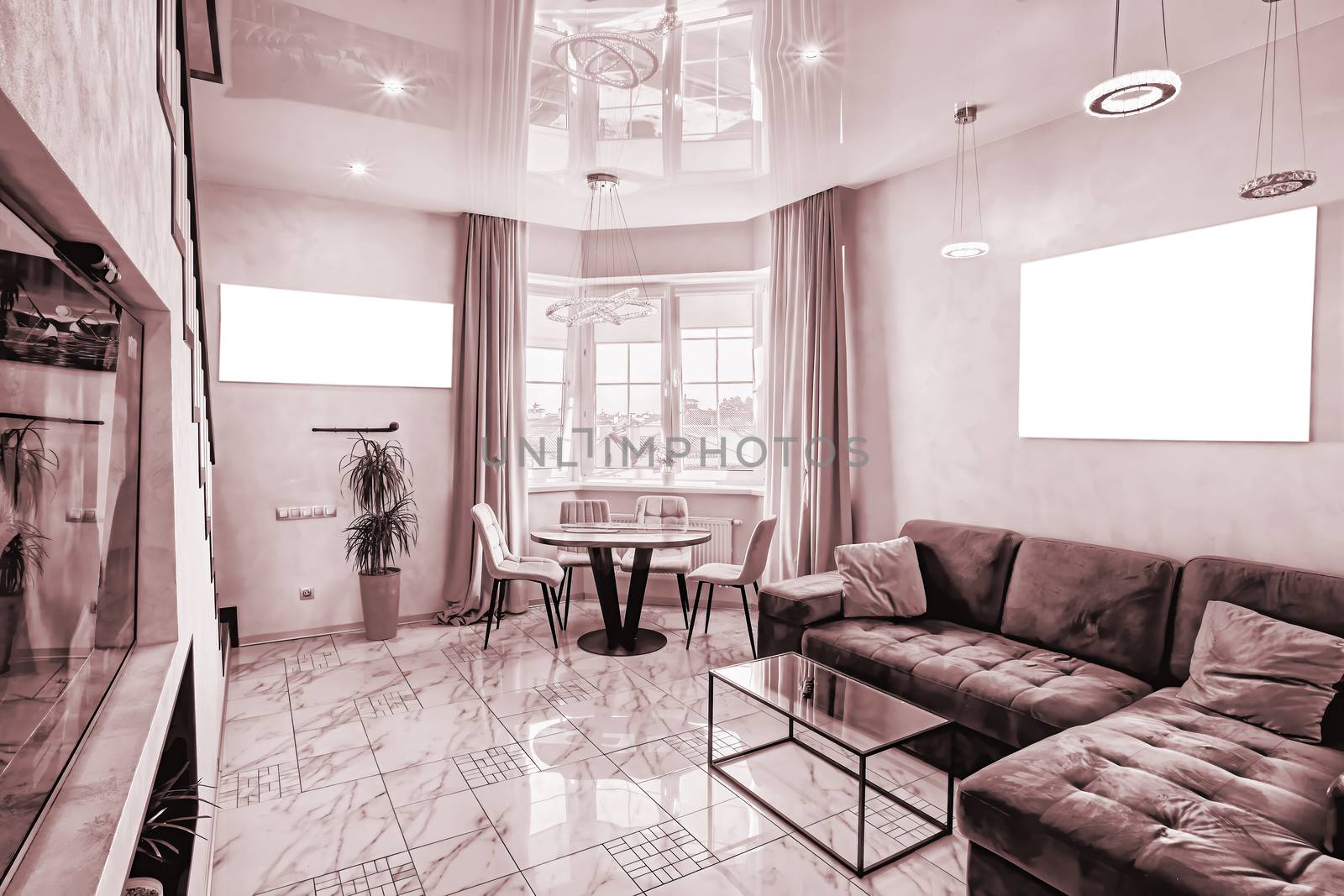 Modern interior of a large and cozy living room with a sofa and a table by the window. Mockup on the wall.