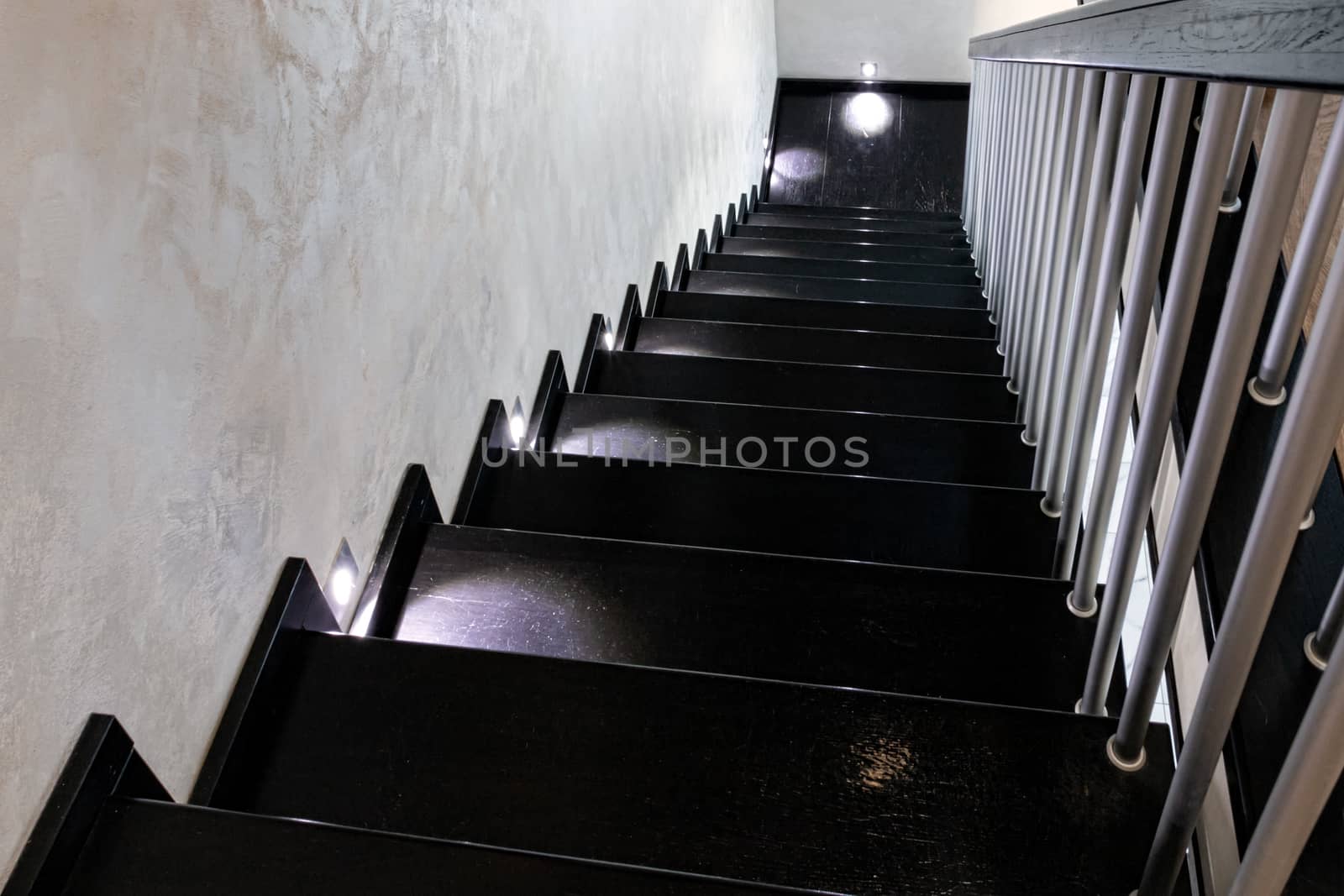 Modern brown wooden staircase with illuminated steps.