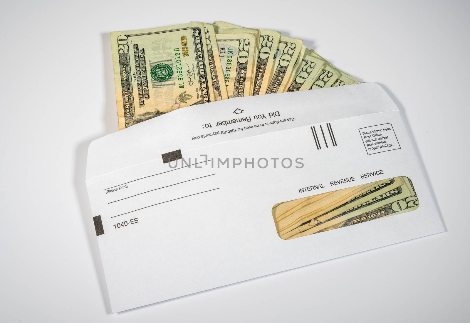 Stack of 20 dollar bills in IRS envelope to illustrate coronavirus stimulus payment or estimated tax payments on white background