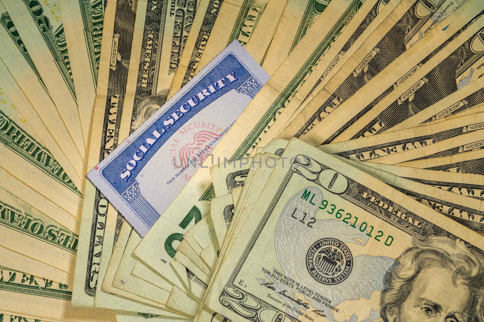 Thousands of US dollars laid out in a flat background perspective with the focus on a social security card