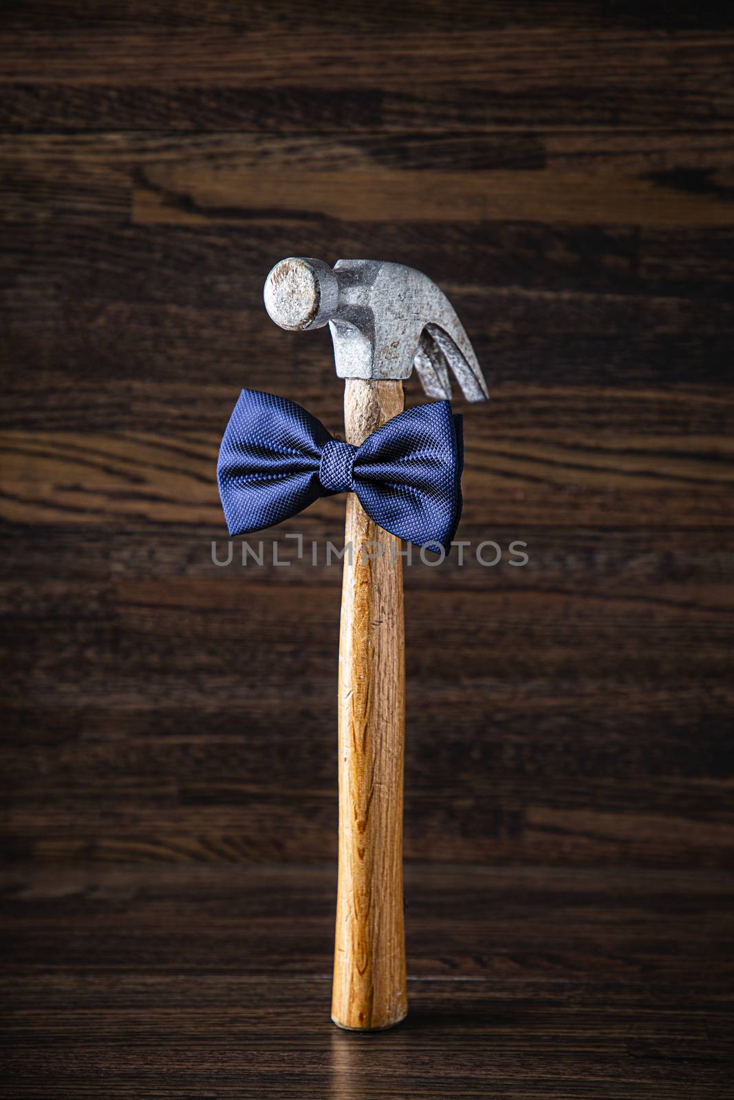Wood handle hammer wearing a blue bowtie