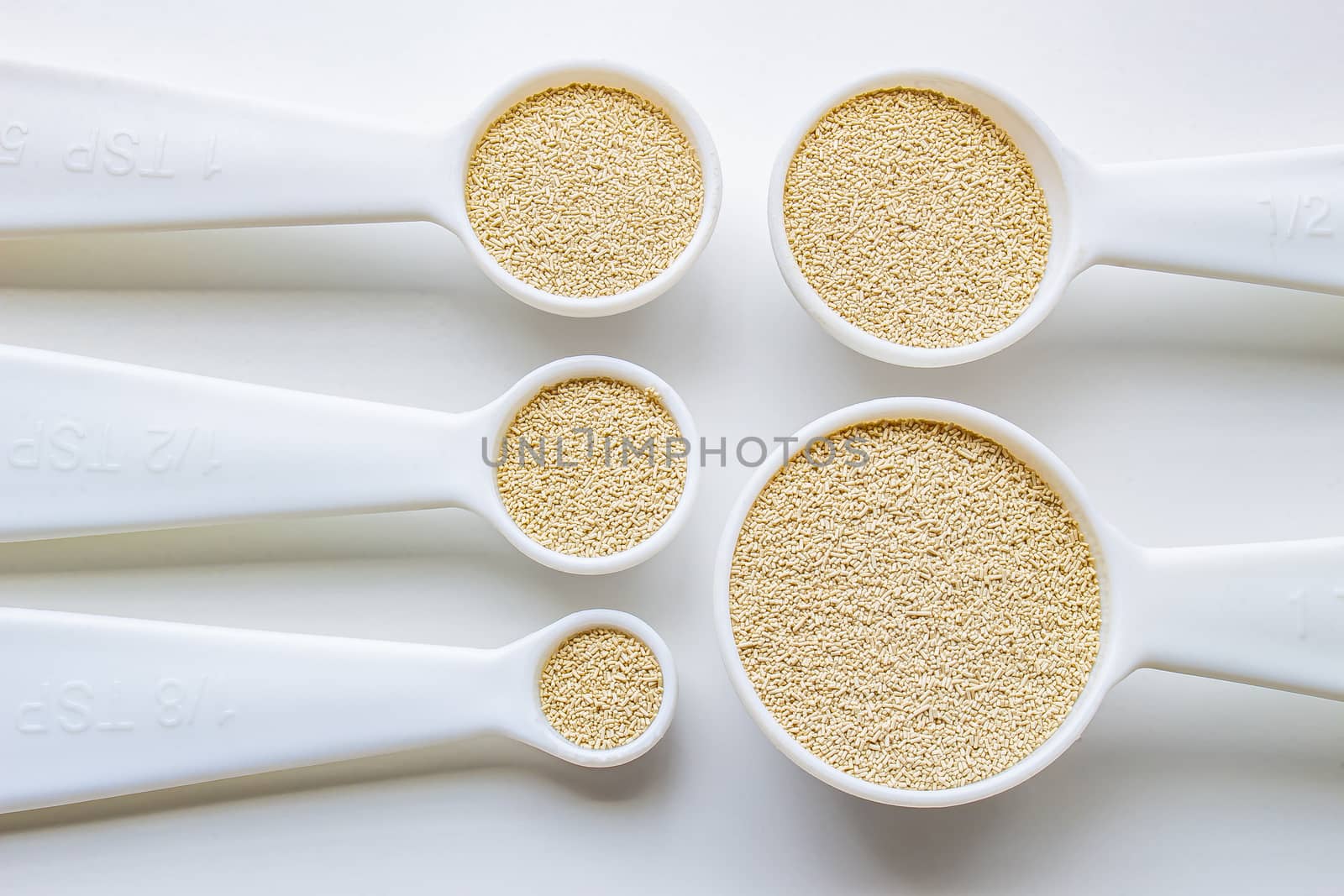A close view of some measurement baking spoons with yeast on them