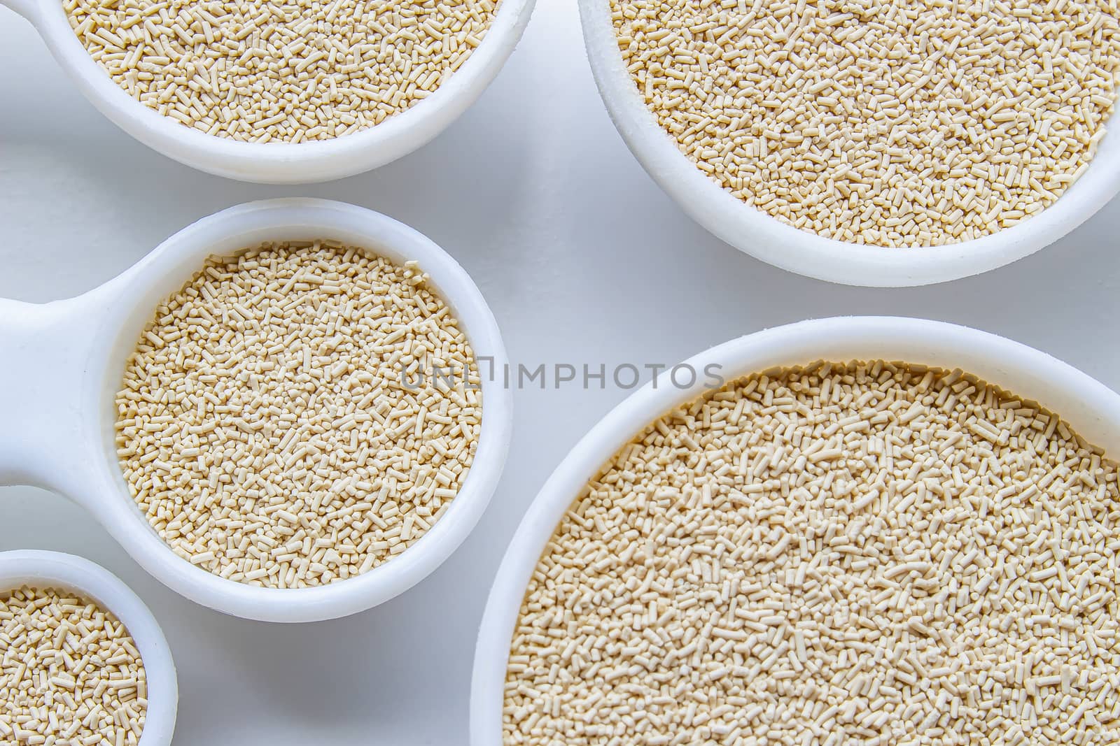 A close up of some measurement baking spoons with yeast on them