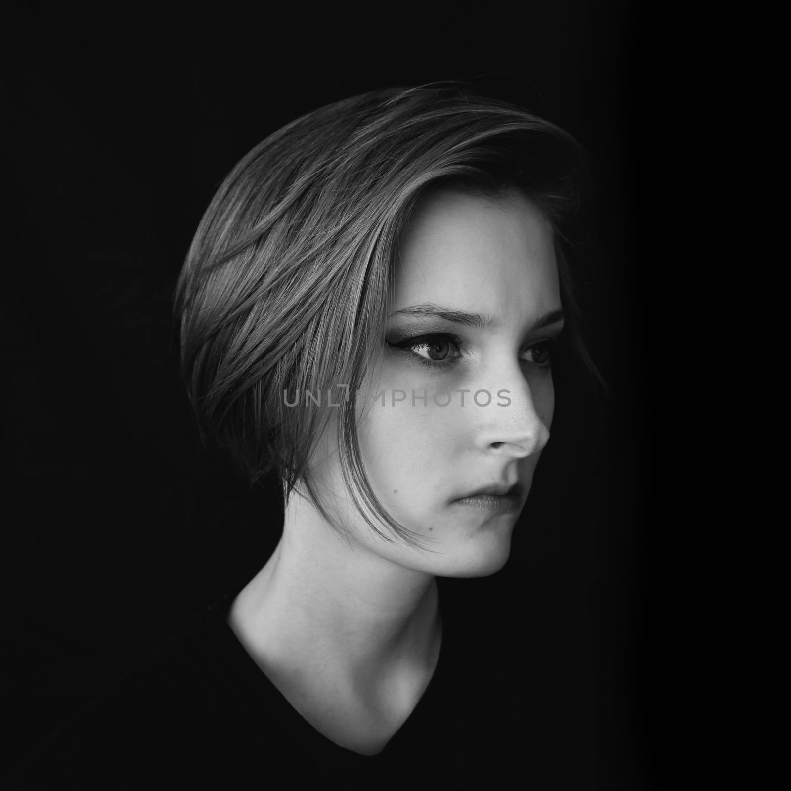 Black and white portrait of a girl on a black background. Powerful energy concept.