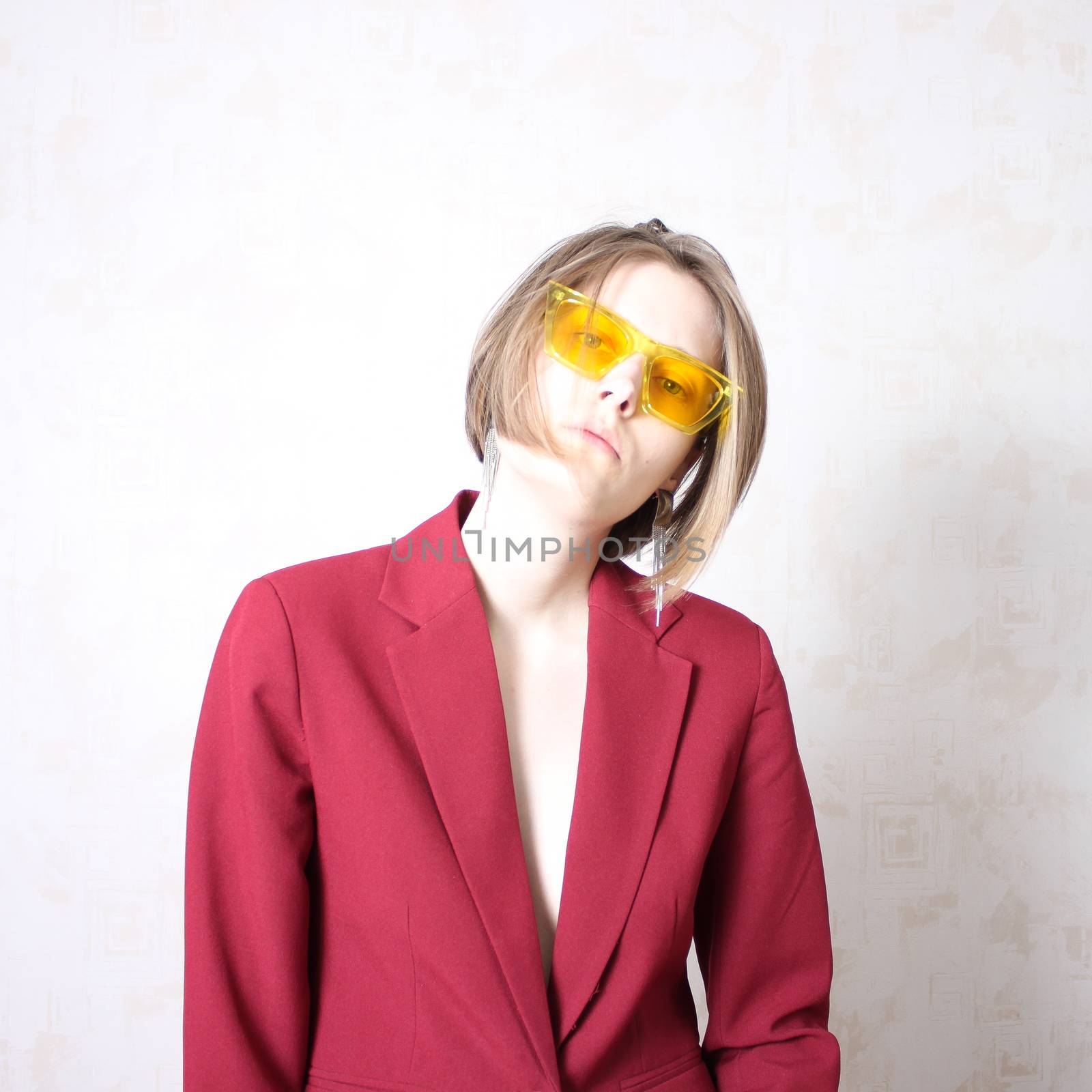 Bright portrait of a girl in yellow glasses. Serious facial expression