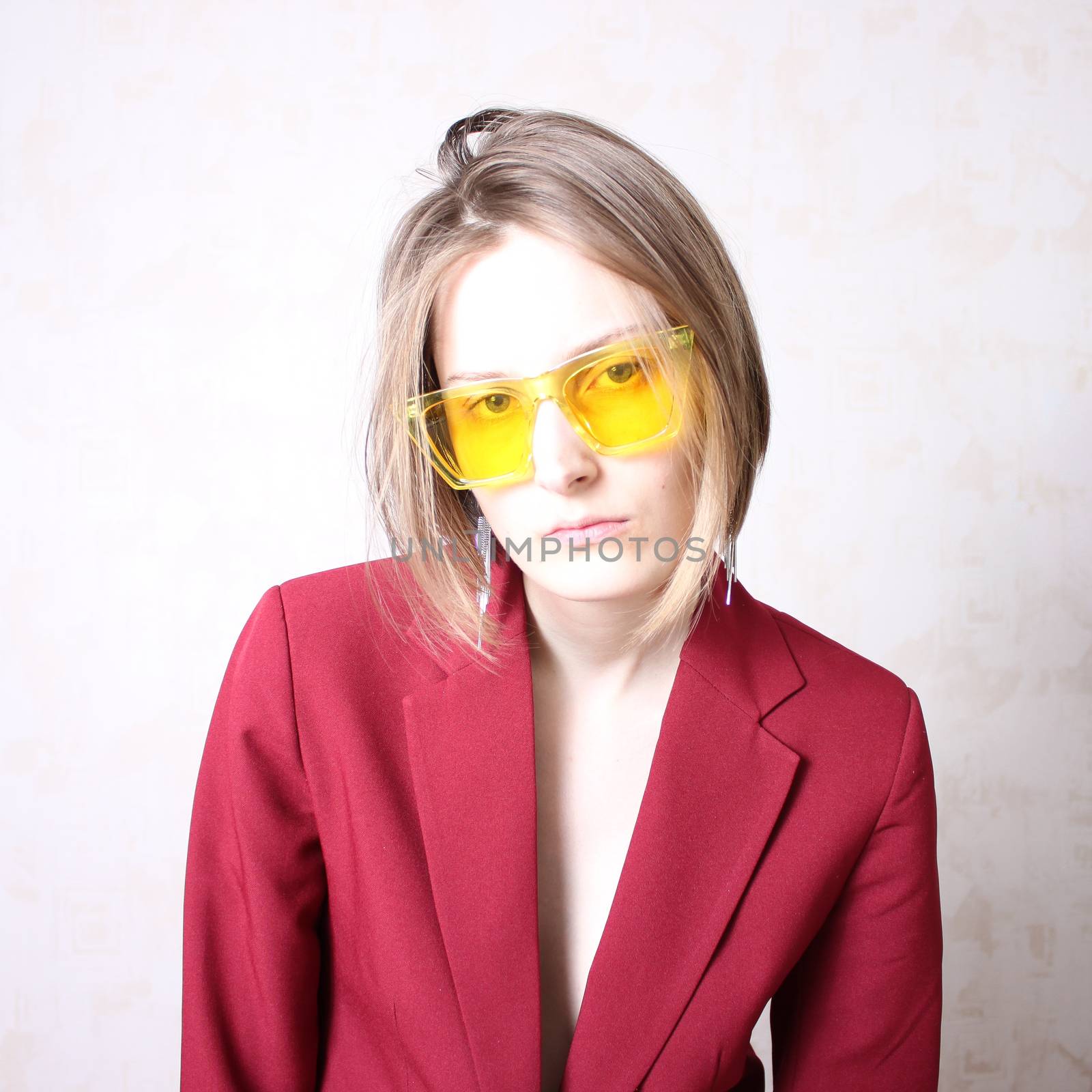 Bright portrait of a girl in yellow glasses. Serious facial expression