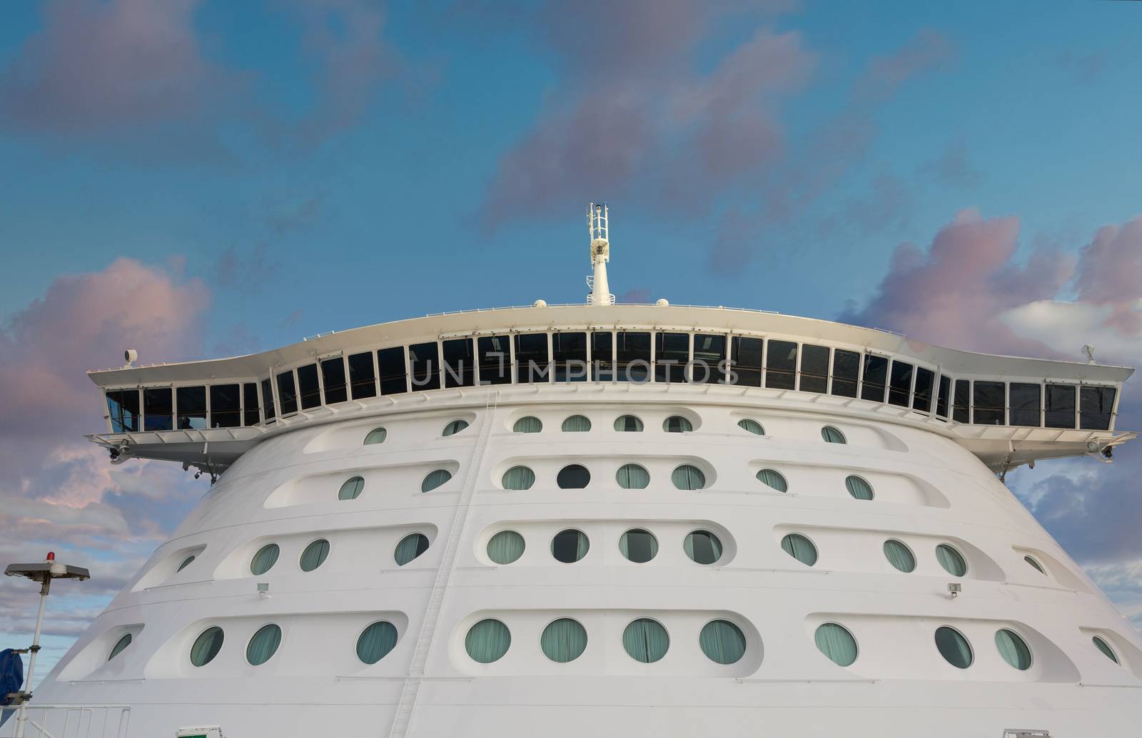 Front of a massive luxury cruise ship with round portholes
