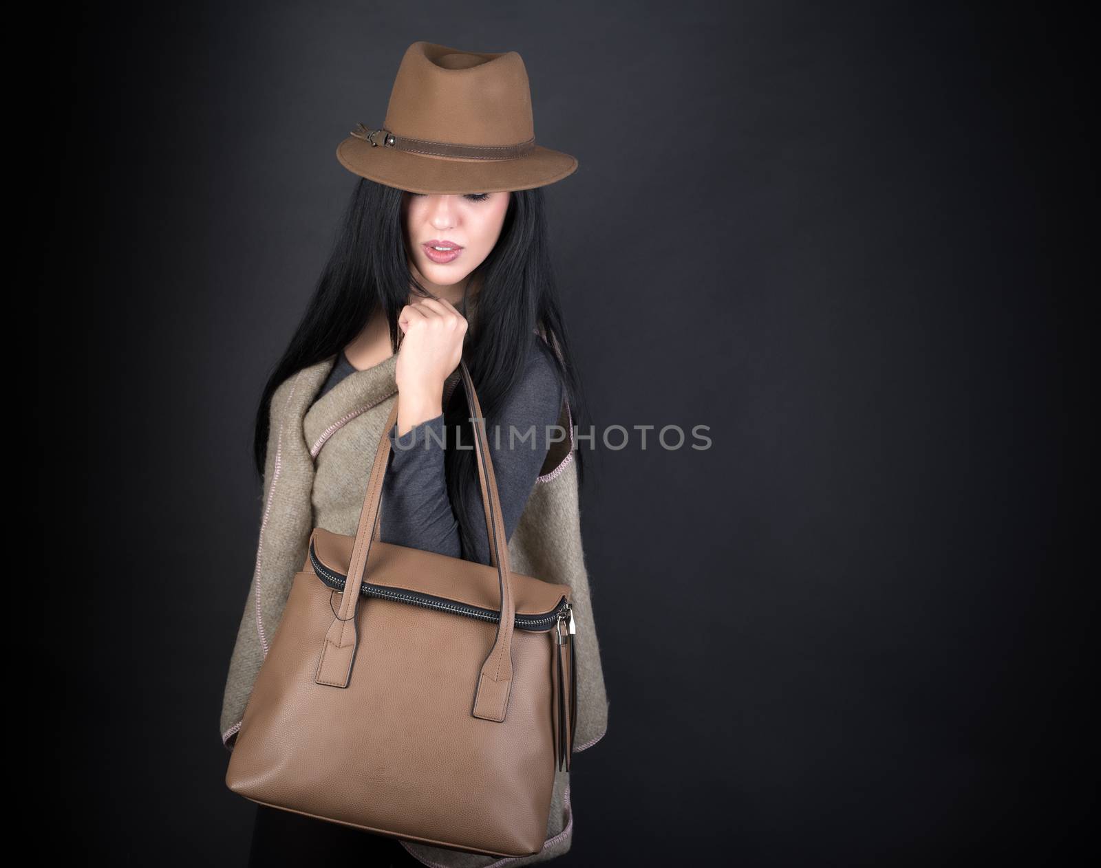 Fashion beautiful woman in country outfit, hat and bag on black background
