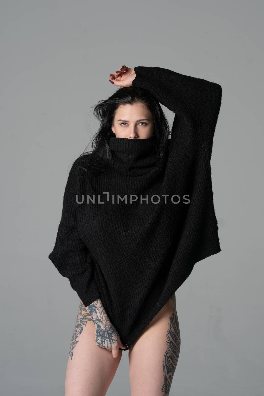 young beautiful girl pose in a black sweater in the studio