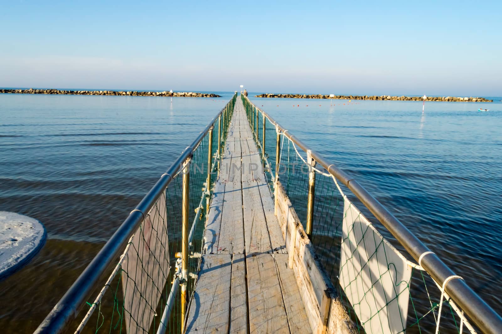 Pier in stainless steel and wood allow the boarding of tourists on the boats of Igea Marina near Rimini in Italy