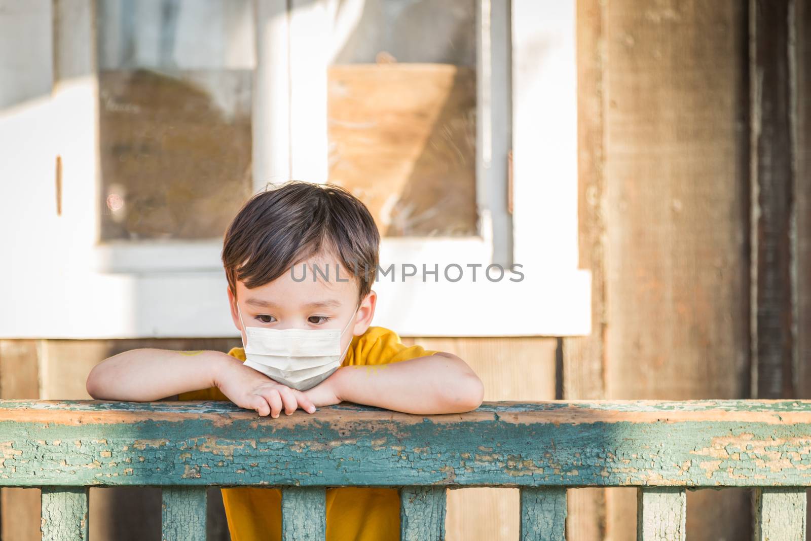 Young Mixed Race Chinese and Caucasian Boy Playing Alone Wearing Medical Face Mask Outside. by Feverpitched