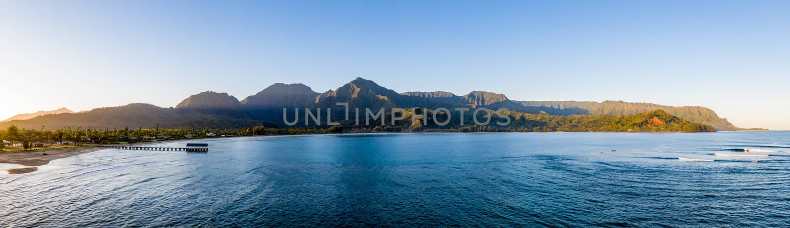 Aerial panoramic image at sunrise off the coast over Hanalei Bay and pier on Hawaiian island of Kauai