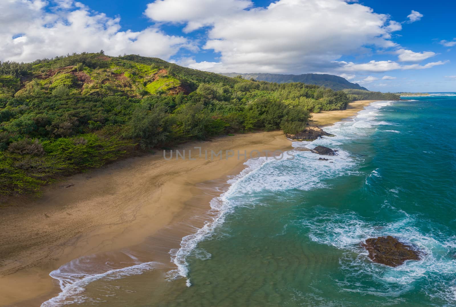Aerial panoramic image off the coast over Lumaha'i beach on Hawaiian island of Kauai with Na Pali mountains behind