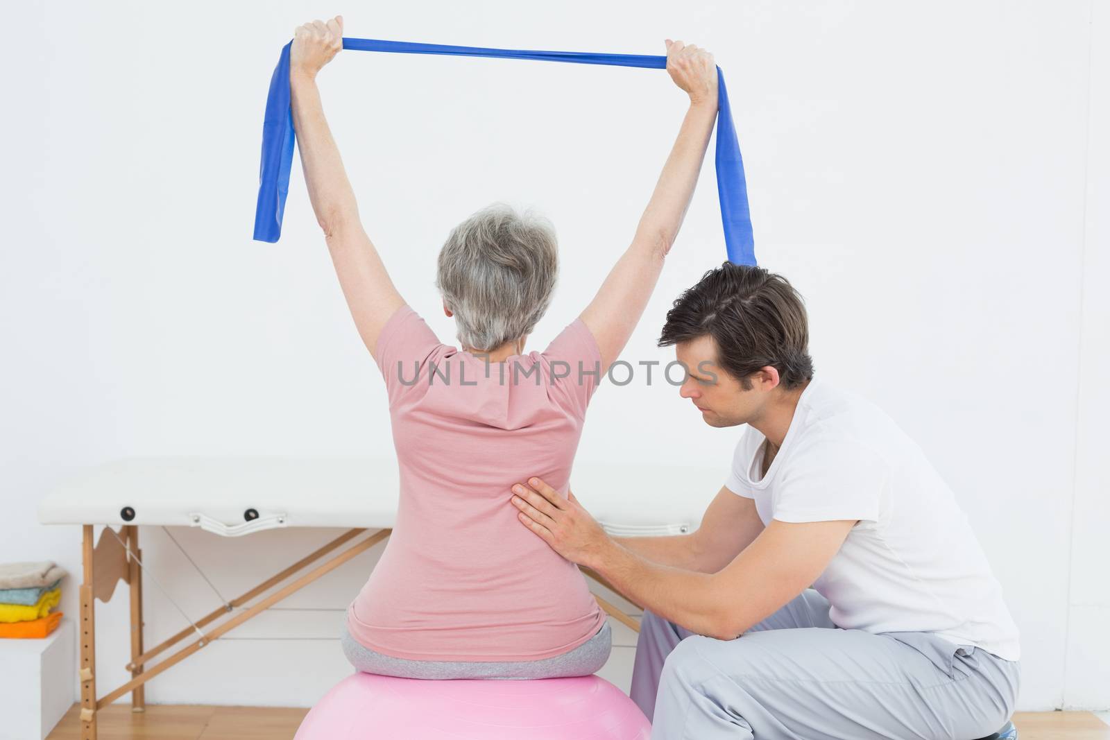 Senior woman on yoga ball with a physical therapist by Wavebreakmedia