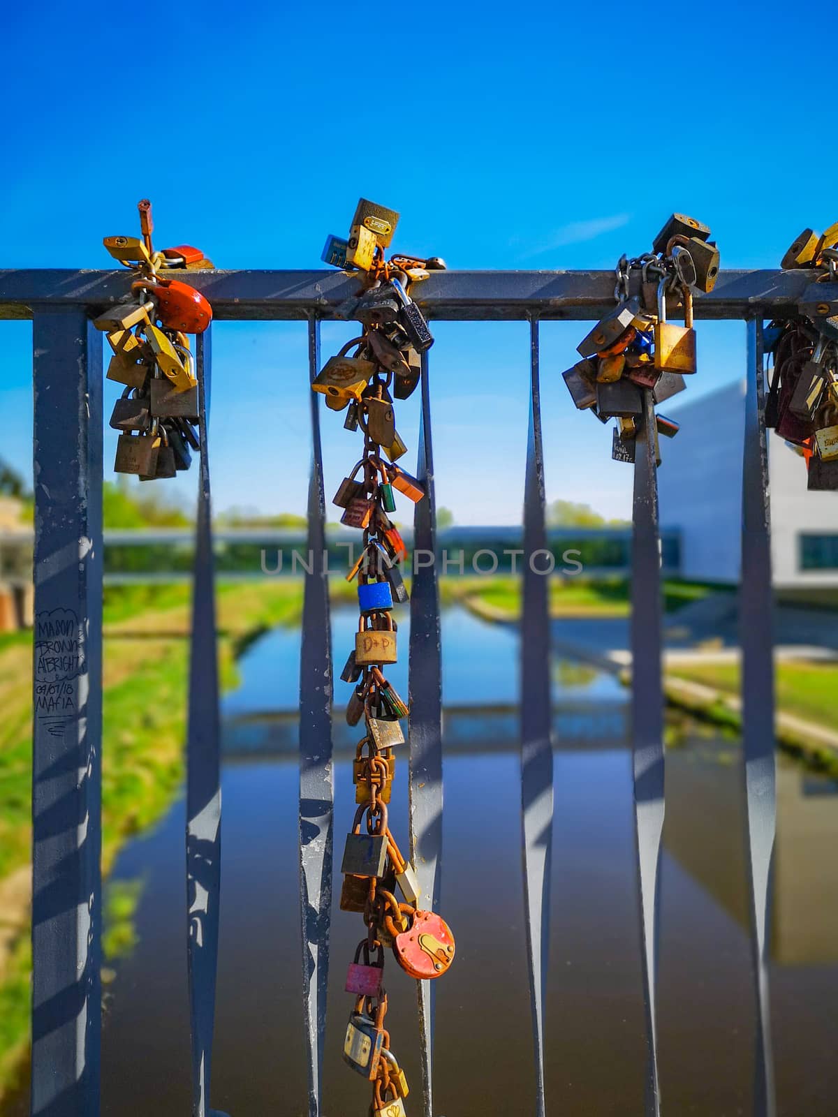 Colorful padlocks hanged on Tumski Bridge in Poznan at sunny day by Wierzchu