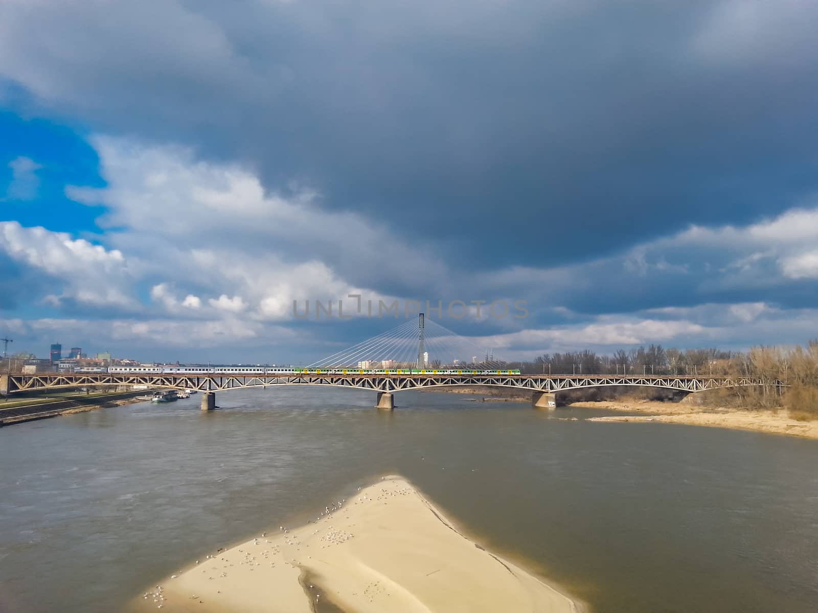 Warsaw cityscape with train bridge and small beach on coast by Wierzchu