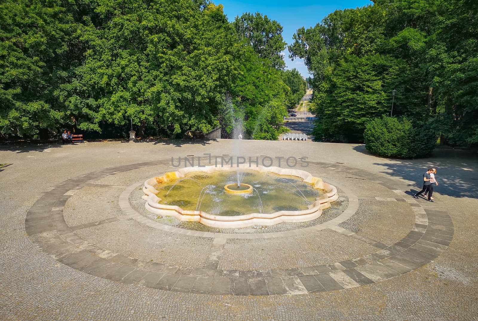 Fountain square with long pathway with concrete pavement by Wierzchu