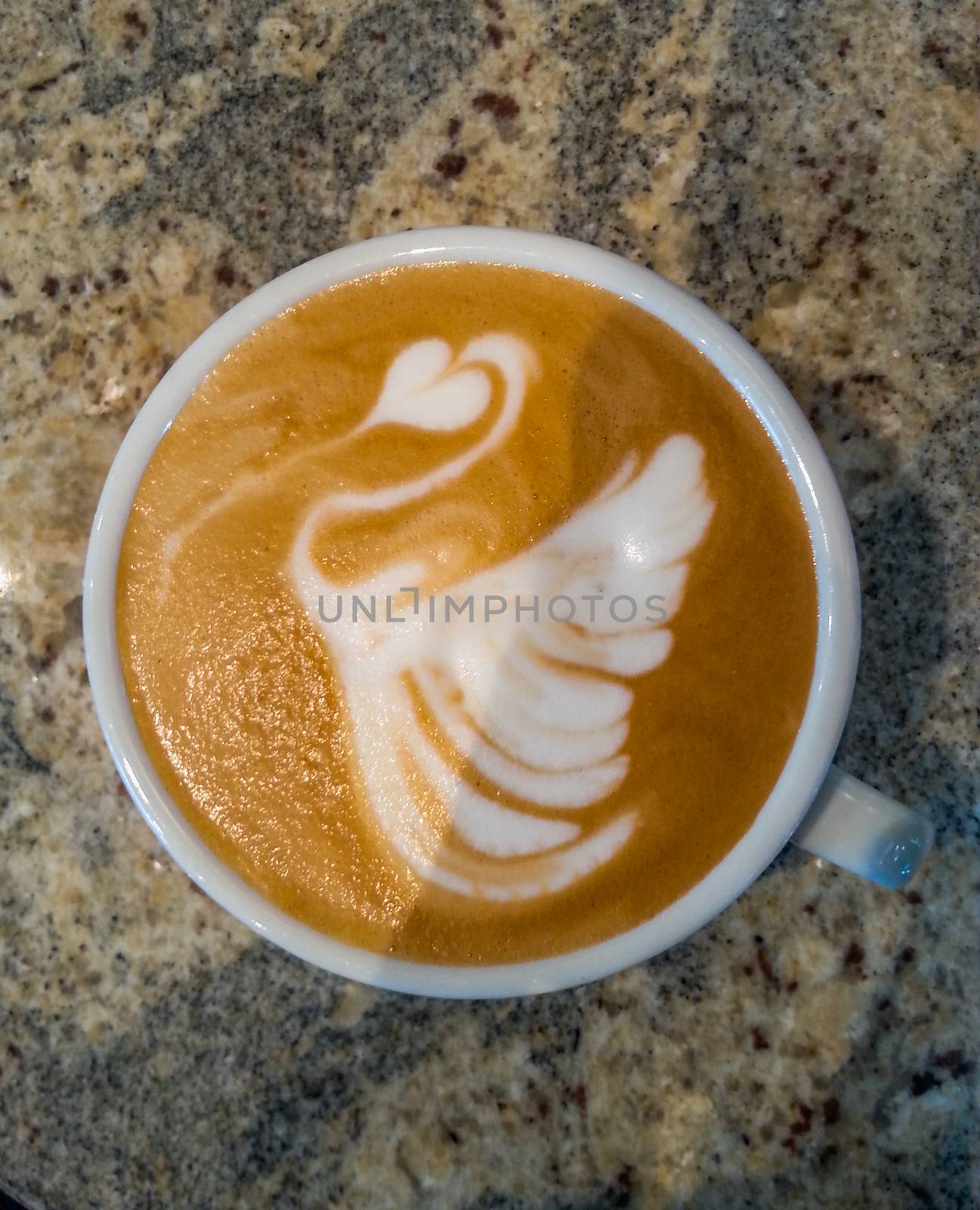 Swan latte art on cafe latte on stone table